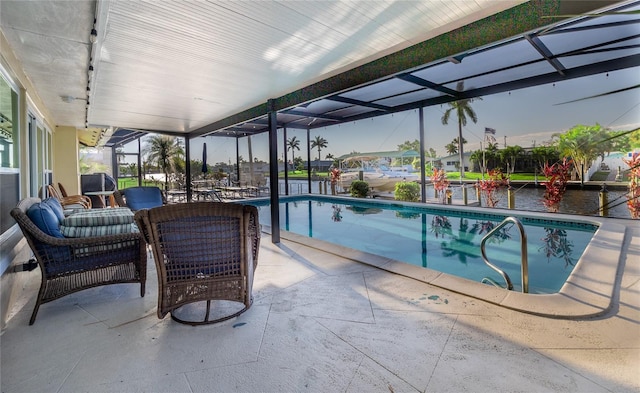 view of pool with a lanai, a patio area, and a water view