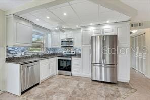 kitchen with white cabinetry, decorative backsplash, and appliances with stainless steel finishes