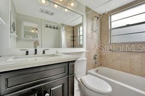 full bathroom with vanity, toilet, and tiled shower / bath combo