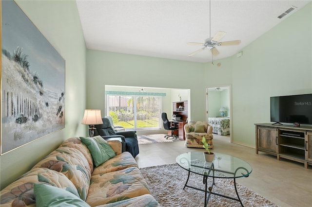 carpeted living room featuring ceiling fan and a high ceiling