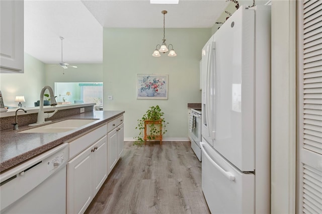 kitchen with light wood-type flooring, white appliances, white cabinetry, and sink