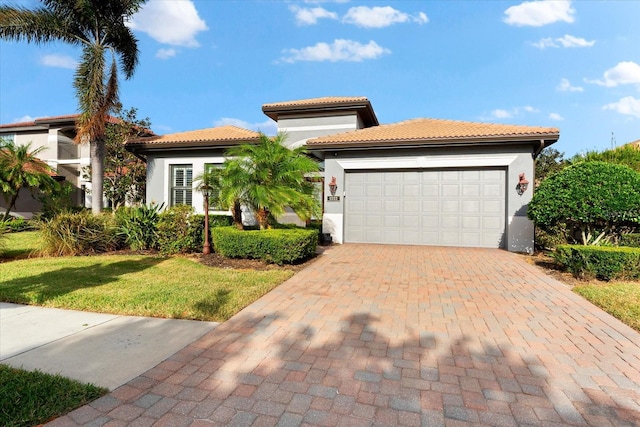 mediterranean / spanish house featuring a garage and a front lawn