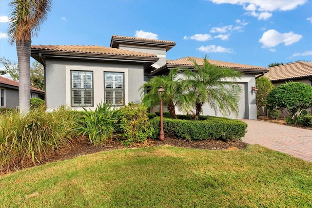 mediterranean / spanish house featuring a garage and a front yard