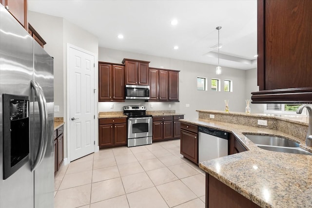 kitchen with appliances with stainless steel finishes, light tile patterned floors, light stone countertops, hanging light fixtures, and sink