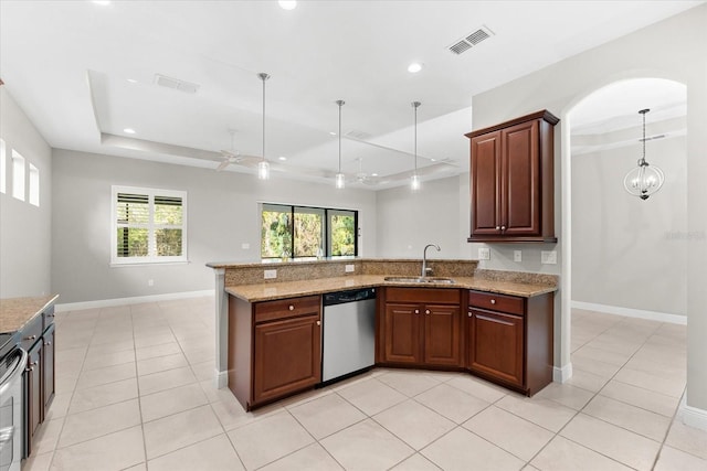 kitchen with pendant lighting, appliances with stainless steel finishes, sink, and a tray ceiling