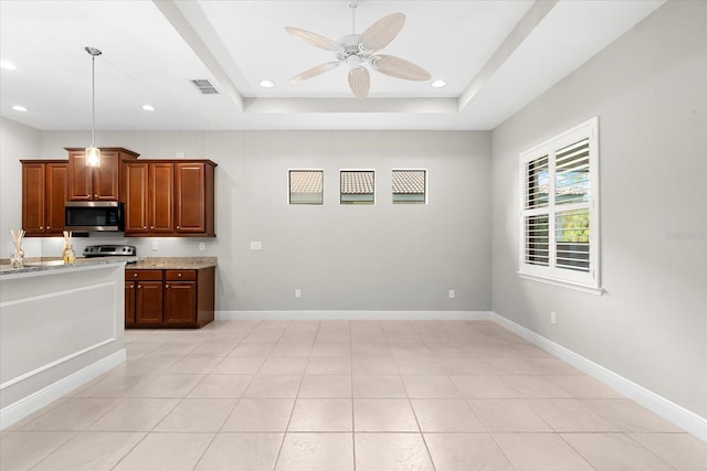 kitchen with stainless steel appliances, ceiling fan, a tray ceiling, and light tile patterned floors