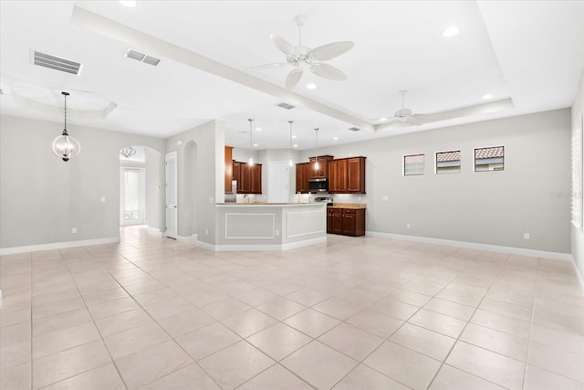 unfurnished living room featuring light tile patterned floors, ceiling fan, and a raised ceiling