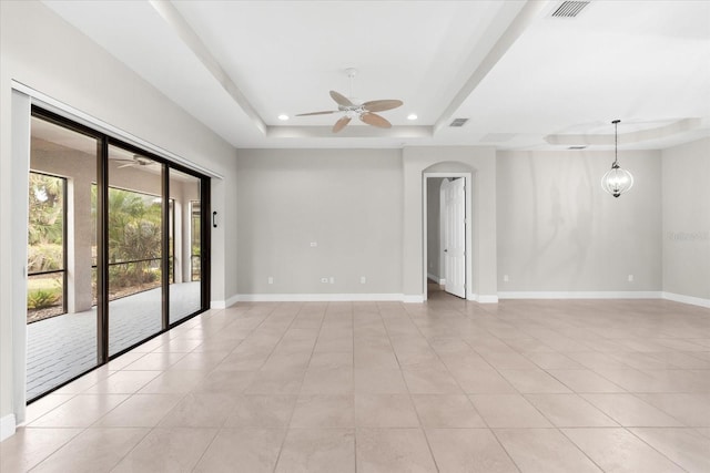 tiled empty room featuring a tray ceiling and ceiling fan