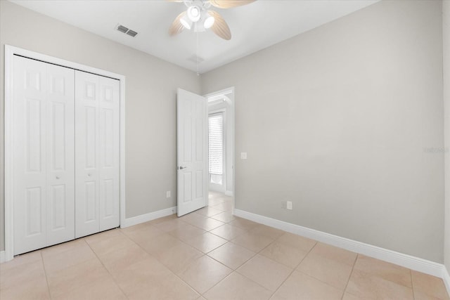 unfurnished bedroom with a closet, light tile patterned floors, and ceiling fan