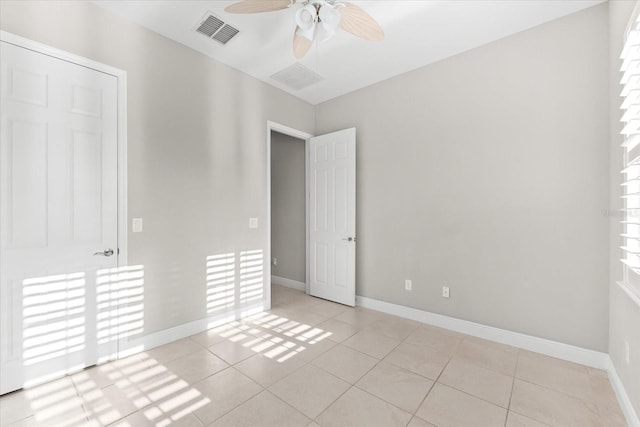 tiled spare room featuring ceiling fan