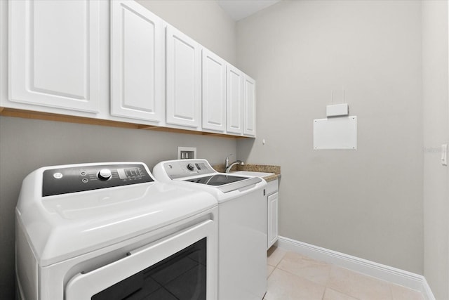 clothes washing area featuring light tile patterned floors, cabinets, sink, and washing machine and clothes dryer