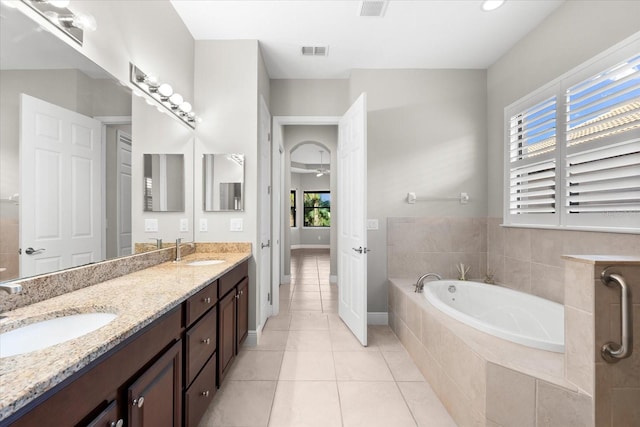 bathroom with vanity, tile patterned floors, and tiled tub