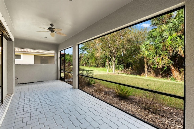 unfurnished sunroom with ceiling fan