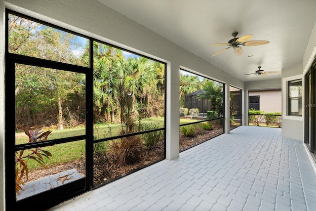 unfurnished sunroom with a wealth of natural light and ceiling fan