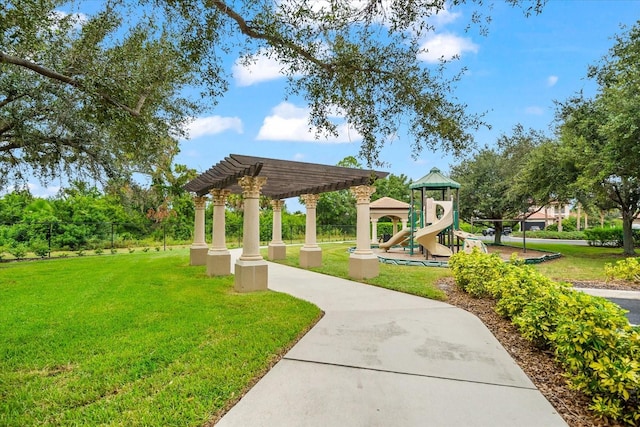 view of community featuring a playground, a pergola, and a lawn