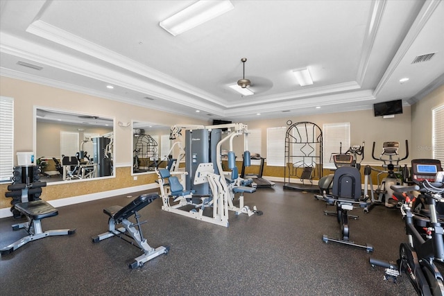 gym featuring a tray ceiling, ceiling fan, and crown molding