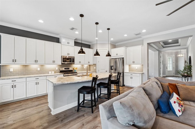 kitchen with appliances with stainless steel finishes, crown molding, white cabinets, light hardwood / wood-style floors, and hanging light fixtures