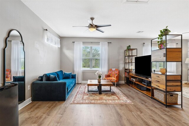 living room featuring hardwood / wood-style floors and ceiling fan