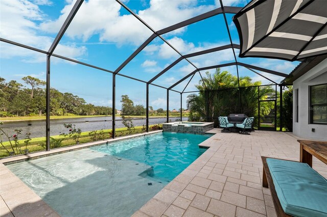 view of pool featuring glass enclosure, a patio area, and an in ground hot tub