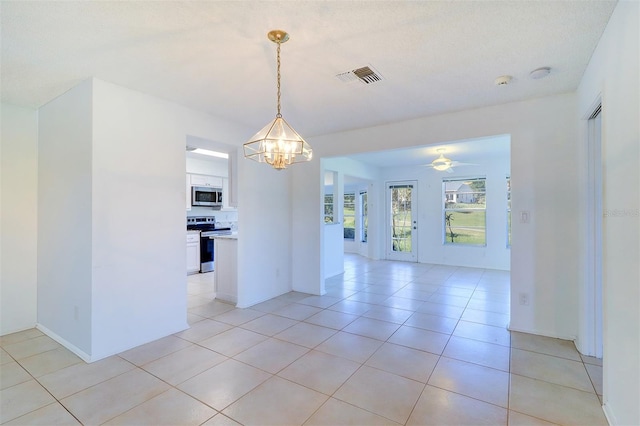 unfurnished room featuring light tile patterned flooring, ceiling fan with notable chandelier, and a textured ceiling