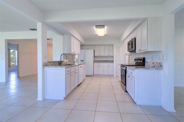 kitchen with white cabinetry, stainless steel appliances, sink, and light tile patterned floors