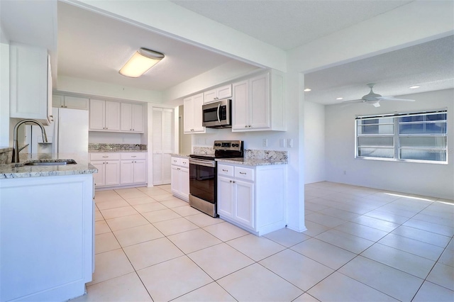 kitchen featuring light tile patterned flooring, white cabinetry, sink, and appliances with stainless steel finishes