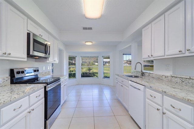 kitchen featuring white cabinetry, sink, light tile patterned flooring, and stainless steel appliances