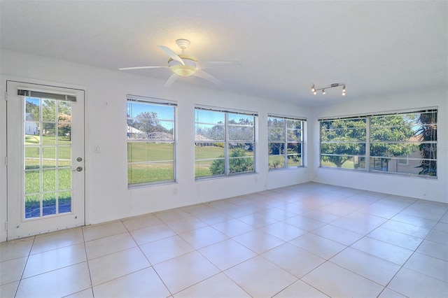 unfurnished sunroom with ceiling fan and plenty of natural light