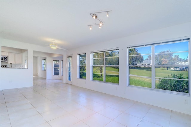 spare room featuring light tile patterned floors and ceiling fan