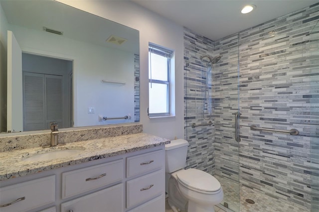 bathroom featuring toilet, vanity, and walk in shower