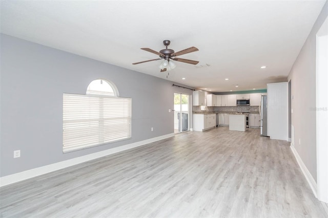 unfurnished living room featuring ceiling fan and light hardwood / wood-style floors