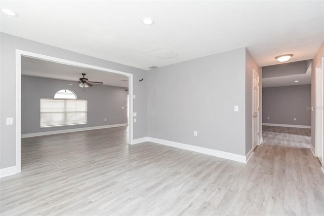 empty room with ceiling fan and light hardwood / wood-style floors