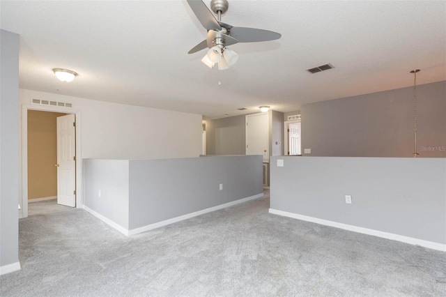 unfurnished room with light carpet, ceiling fan, and a textured ceiling