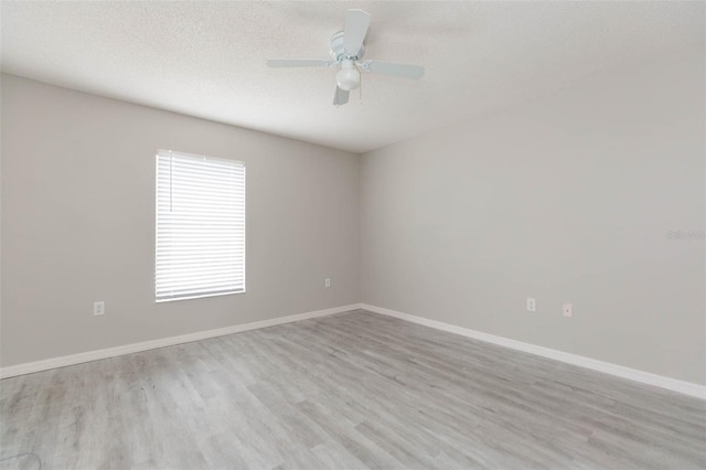 empty room with a textured ceiling, light hardwood / wood-style flooring, and ceiling fan