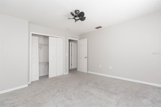 unfurnished bedroom with light colored carpet and a closet