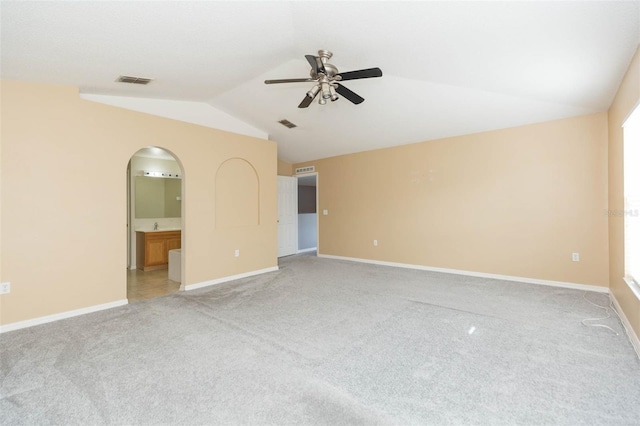 carpeted spare room featuring ceiling fan and lofted ceiling