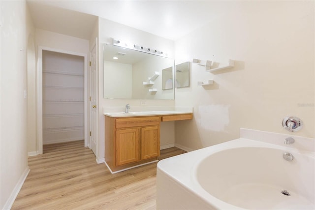 bathroom with wood-type flooring, vanity, and a bathing tub