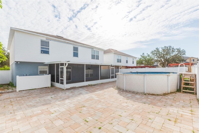 rear view of property featuring a sunroom and a patio