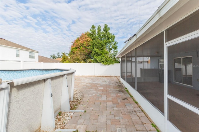 view of patio featuring a fenced in pool and a sunroom