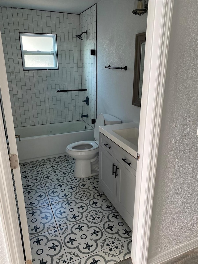 full bathroom with toilet, tiled shower / bath combo, vanity, and tile patterned floors