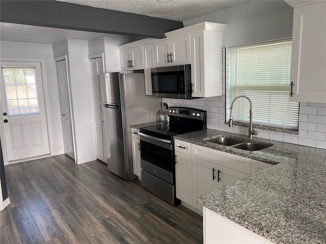 kitchen with sink, white cabinets, a textured ceiling, and stainless steel appliances