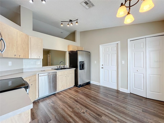 kitchen with stainless steel appliances, hanging light fixtures, light brown cabinetry, and dark hardwood / wood-style floors