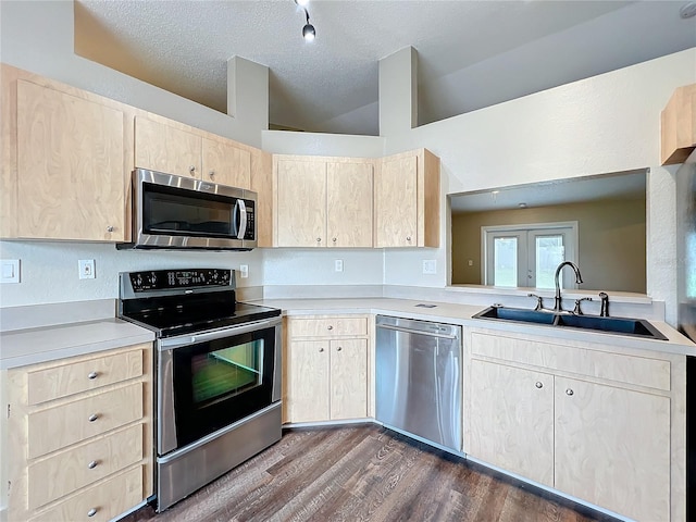 kitchen with dark wood-type flooring, a textured ceiling, sink, light brown cabinets, and appliances with stainless steel finishes