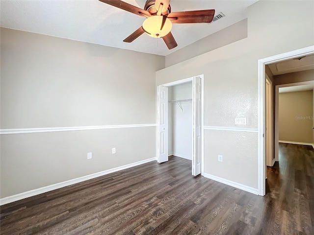 unfurnished bedroom featuring dark hardwood / wood-style flooring, ceiling fan, and a closet