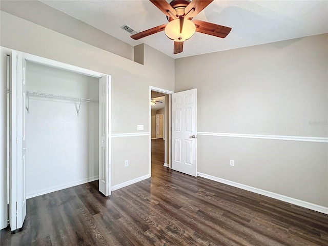 unfurnished bedroom featuring ceiling fan, dark hardwood / wood-style floors, a closet, and a textured ceiling