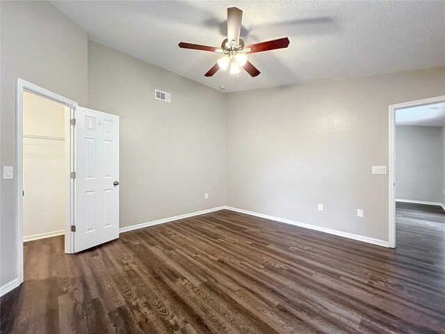 spare room with a textured ceiling, dark hardwood / wood-style flooring, and ceiling fan