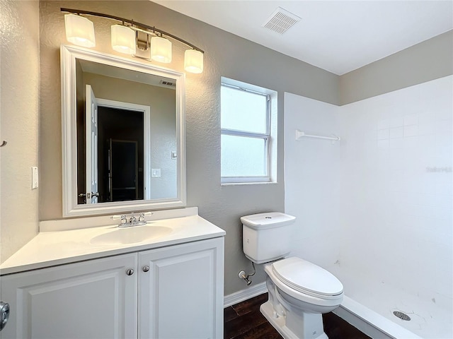 bathroom featuring toilet, a shower, vanity, and wood-type flooring