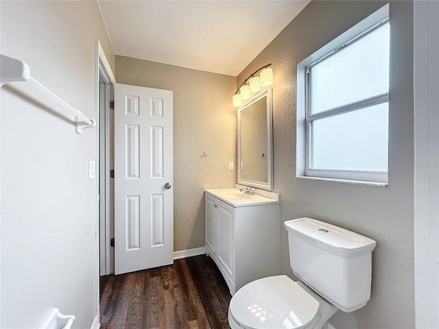 bathroom featuring toilet, vanity, and hardwood / wood-style floors