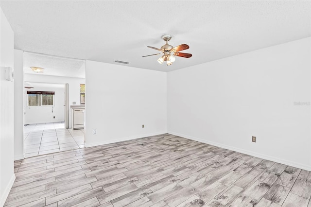 unfurnished room with ceiling fan, a textured ceiling, and light hardwood / wood-style flooring