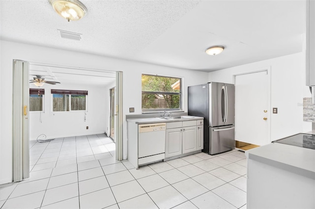 kitchen with ceiling fan, dishwasher, sink, a textured ceiling, and stainless steel fridge